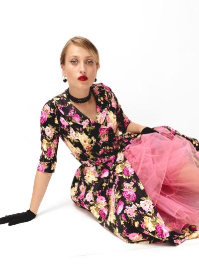 Midnight Floral Elegance Модель сидить на підлозі, з-під квіткової сукні міді визирає пишний рожевий фатин, чорні рукавички