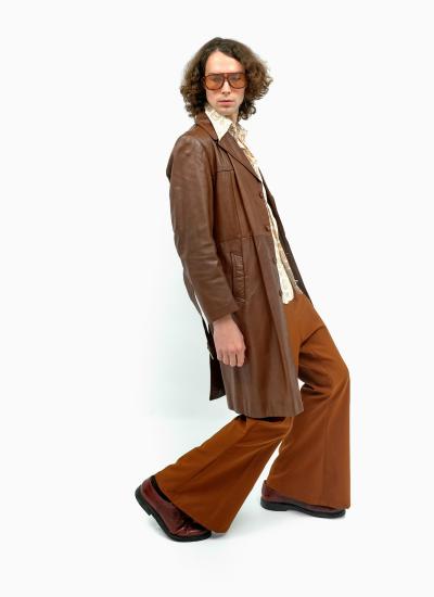 Retro Chocolate Maverick Шкіряний плащ чоловічий 70-х: довгий коричневий, з рудими кльошами й бордовими туфлями, поза з відставленою ногою